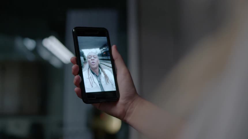 Two people talk via video chat on cell phones
