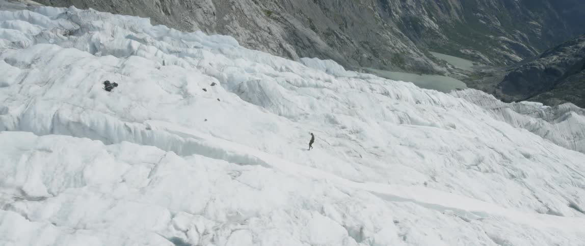 Person walking up a snow covered mountain peak