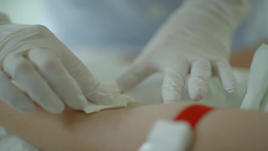 A medical worker wipes an arm