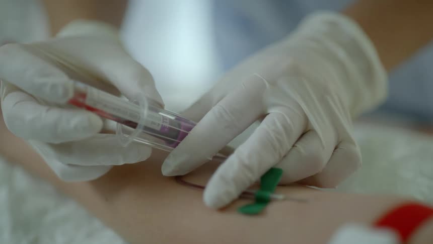 A nurse is drawing blood from a patient
