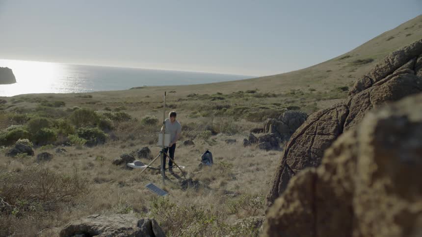 A man setting up an easel near the ocean