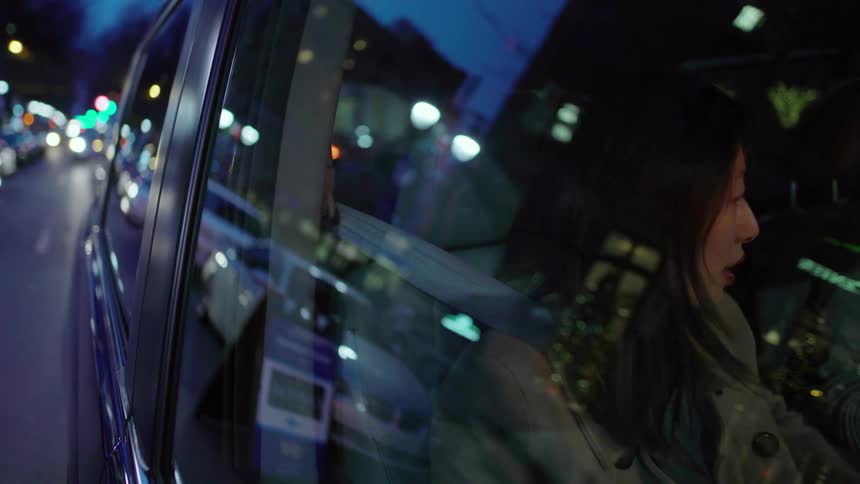 A woman rides in a truck through the city