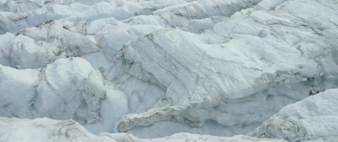The ice mountain leads down to rocks below