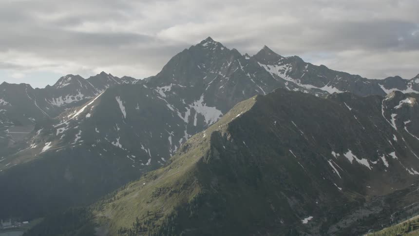 The mountains are in straight rows and have some snow on them