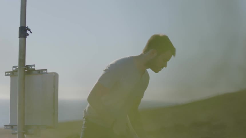 A man adjusts weather monitoring equipment