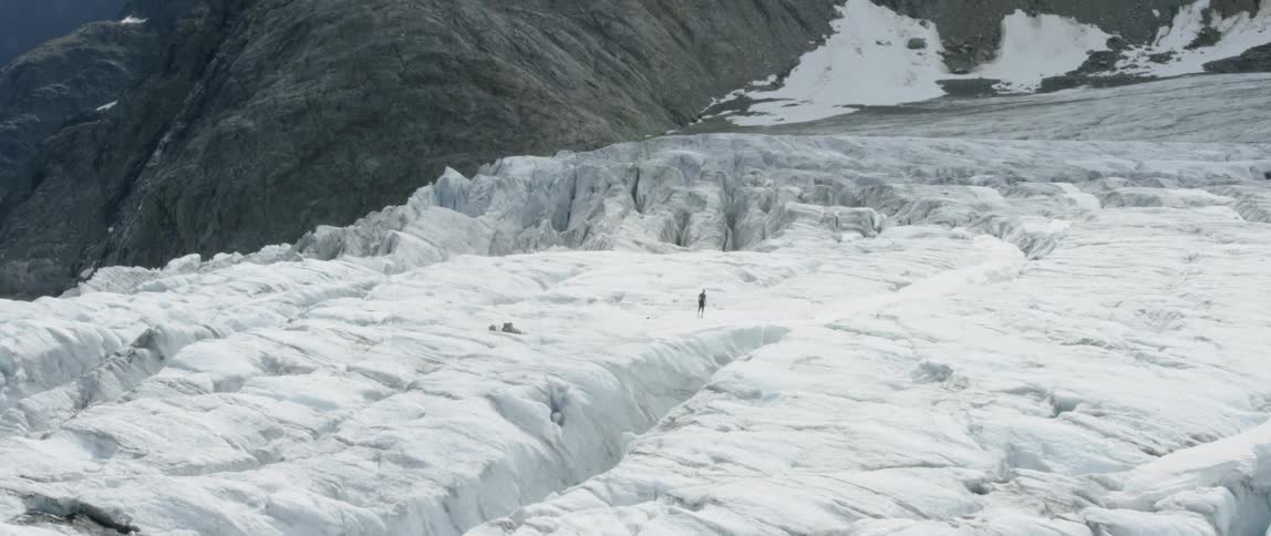 A hiker walks up a snowy mountain
