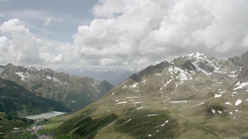 Helicopter Timelapse - Clouds hang above tall mountains