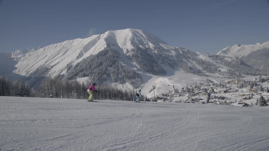 Skiers travel down slopes during the day at a ski resort