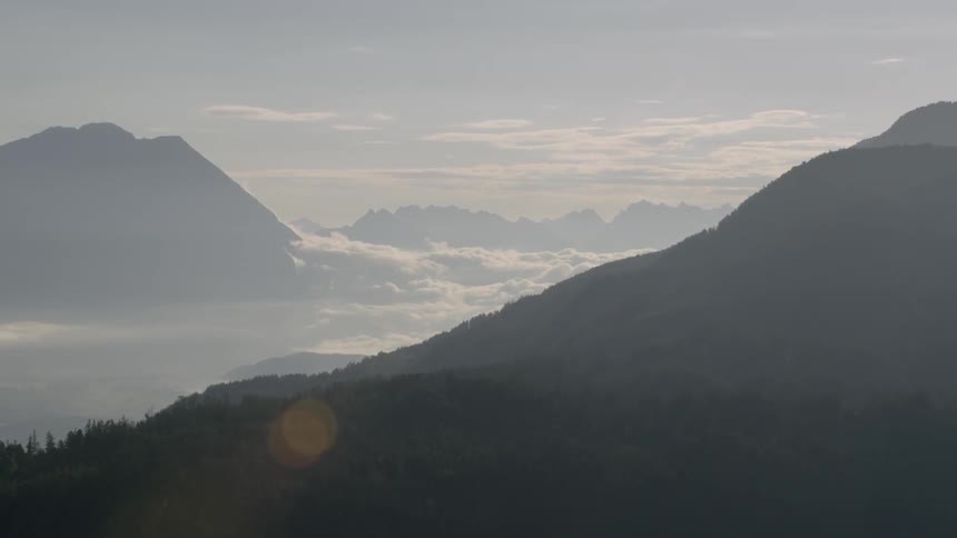 The high mountains covered with trees on a foggy day