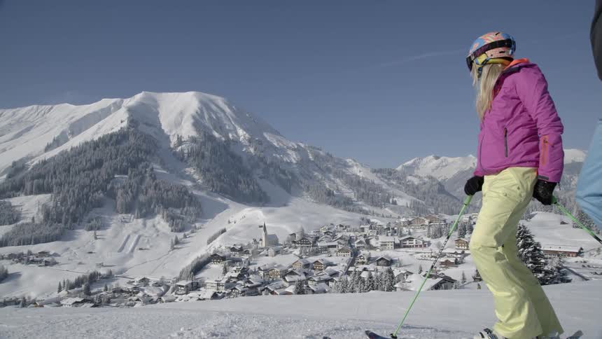 A woman wearing skis near a mountain