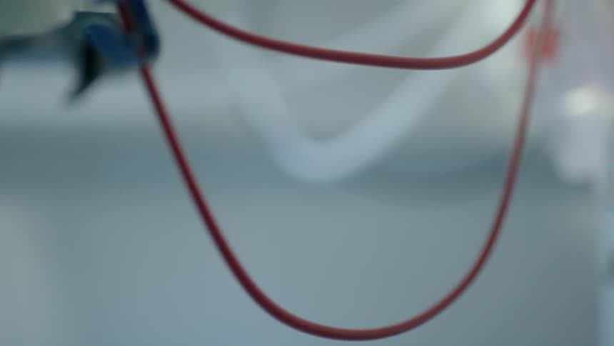A red electrical cable hangs from supports