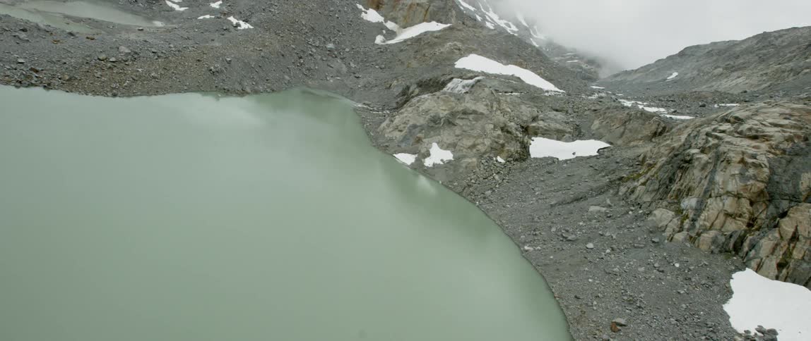 A lake sits in snowy mountains