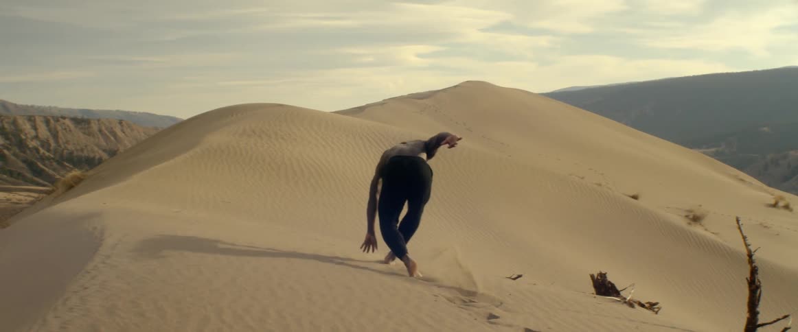 Man walking and stumbling through sand in desert