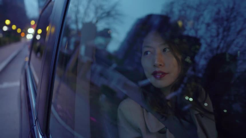 Woman looks out the passenger window of a moving vehicle