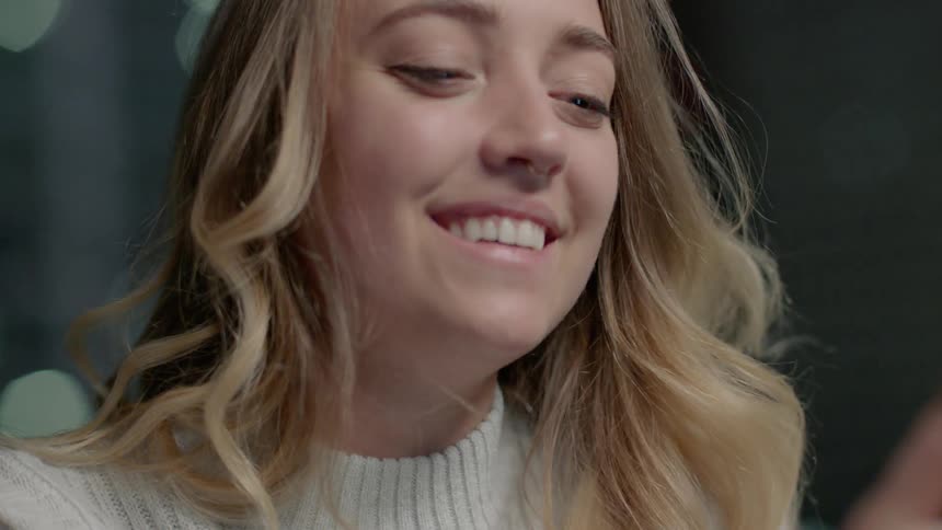 Woman smiles while looking at phone