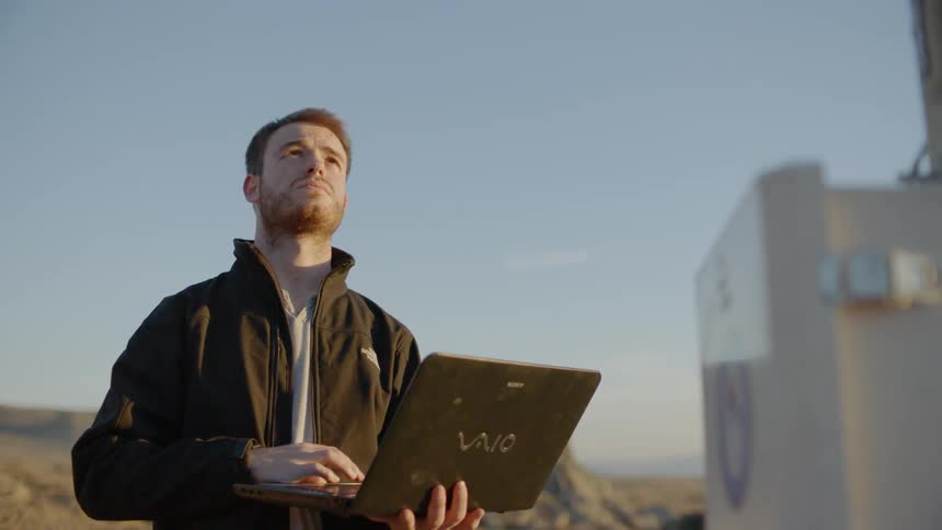 A man is using a laptop next to a power station