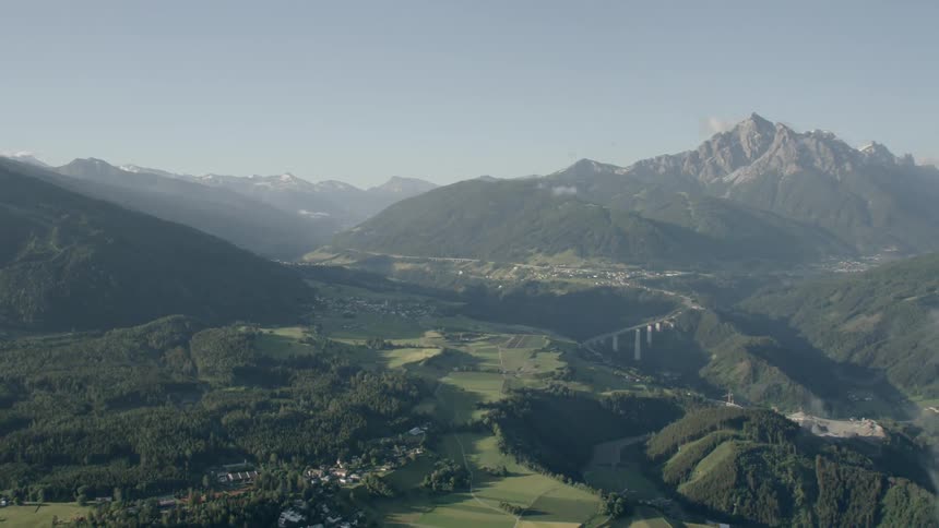 A massive green valley with a mountain in the background