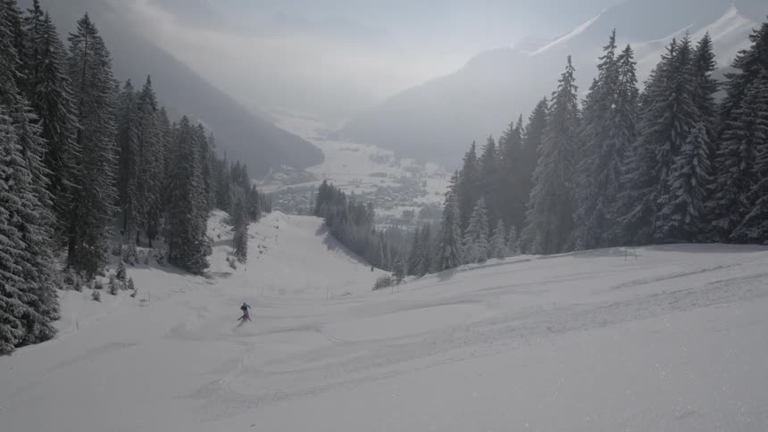 Skiers descend the slope