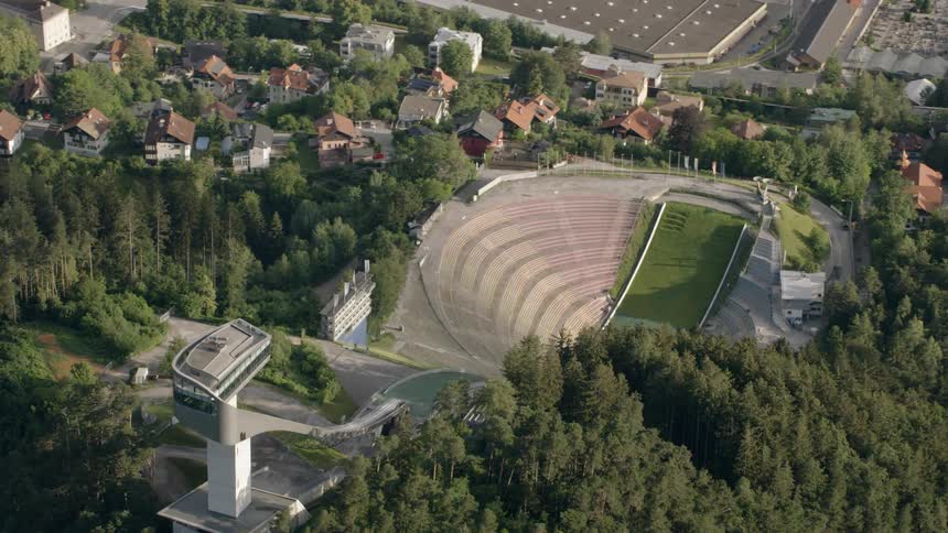 The Bergisel ski jump sits idle in a village on a sunny day