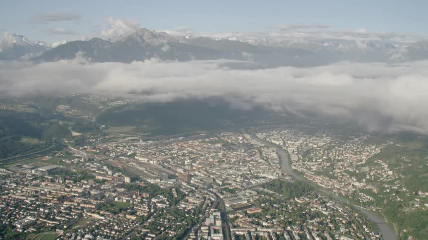Clouds hover over the city Innsbruck surrounded by mountains