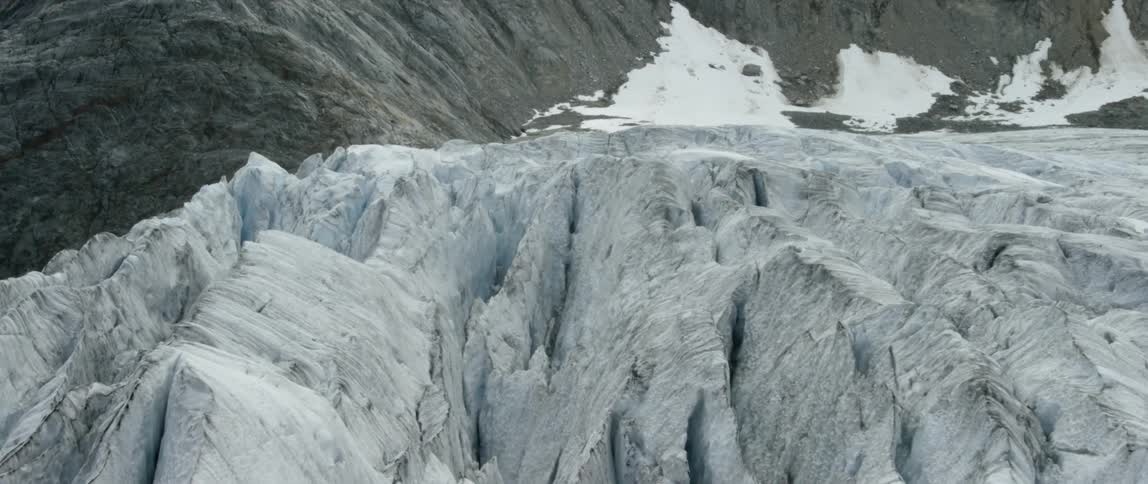 Snow covers a rocky mountainside