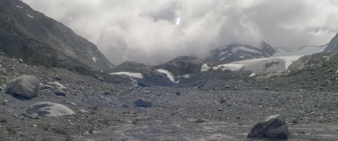 Clouds float over snowy mountains