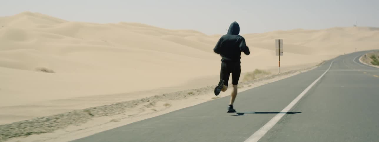 Man runs on a desert road
