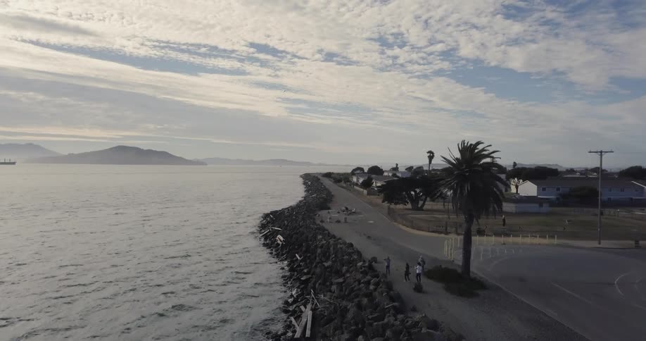 People standing along an oceanside road