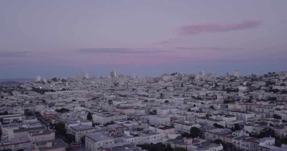 City buildings cover the ground at dusk