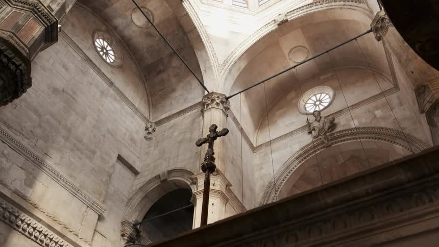 A cross sits in a stone cathedral