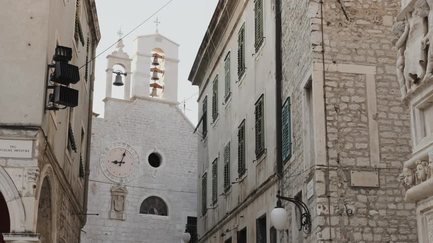 Bells are ringing on a church tower in an old city during the day
