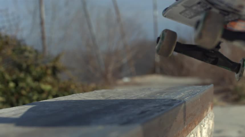 A skateboarder jumps on a concrete barrier