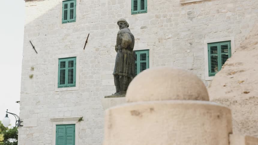 A large statue of a man sits in front of this building