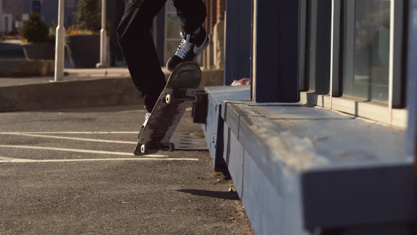 A man does a jump and grind on a skateboard