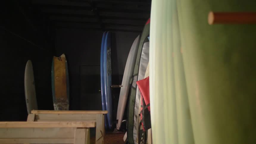 Surfboards line the walls of a storehouse
