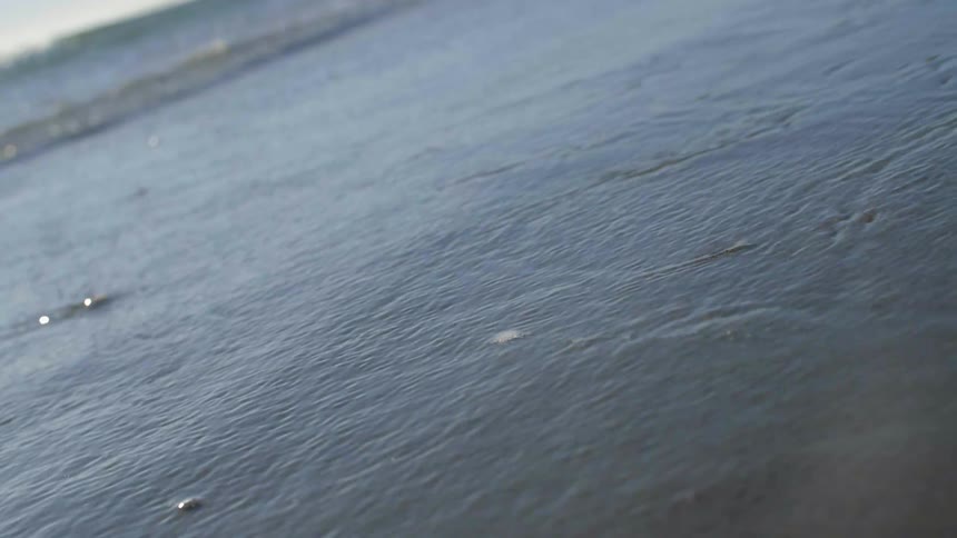 The tide flows onto the shore and recedes