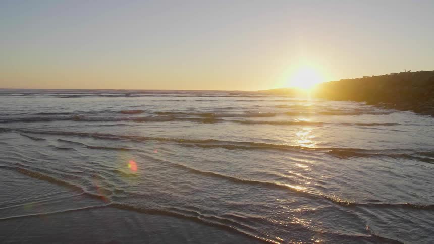 The sun is slowly setting over a beach
