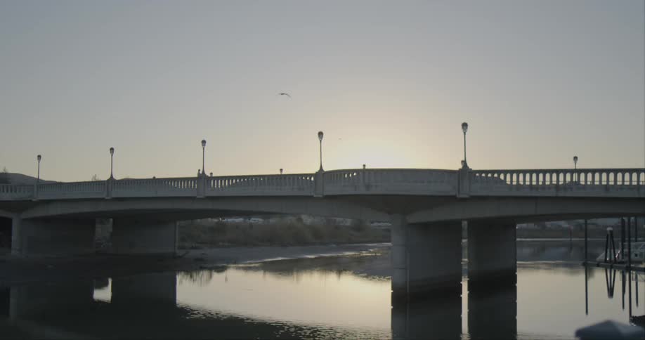 A person runs on a bridge as a car passes them