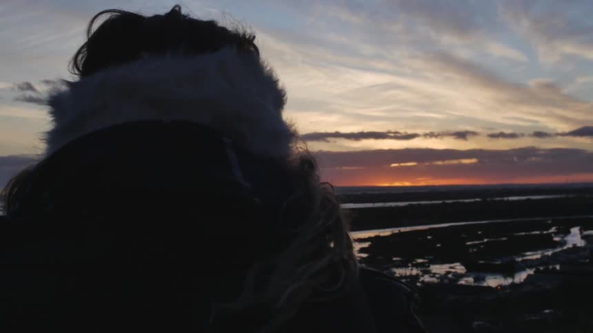 Person overlooks a large range as the sun sets
