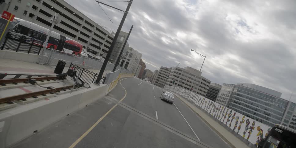 A single car drives across the road towards the city