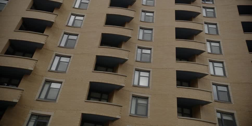An apartment building is filmed from the street level