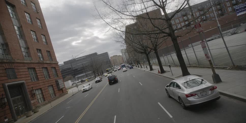 Cars are traveling down the road on a very cloudy day