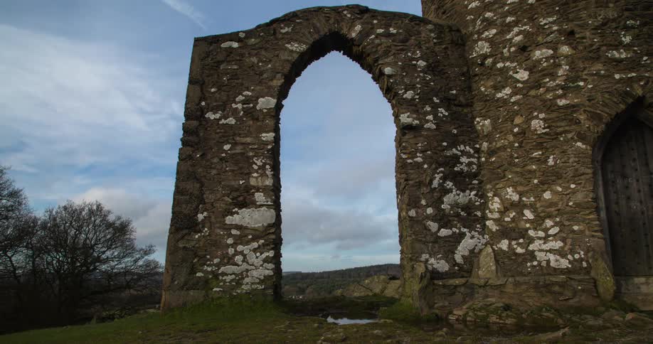 An arch stands as clouds roll by