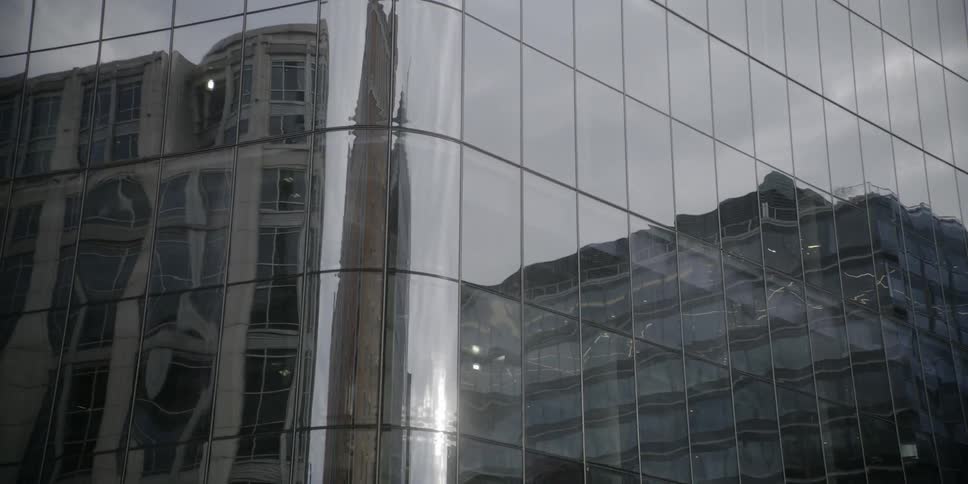 The building is covered with reflective windows on a cloudy day