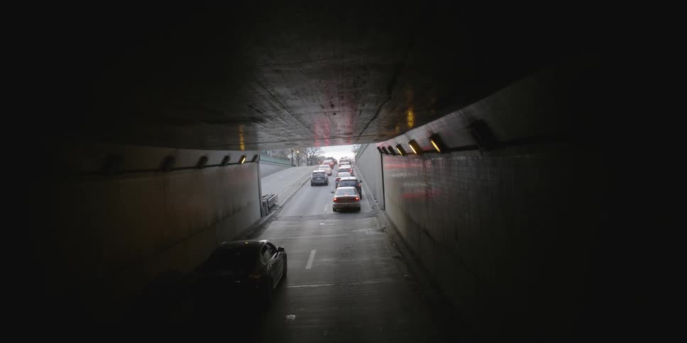 The cars are exiting the tunnel to be stopped in traffic