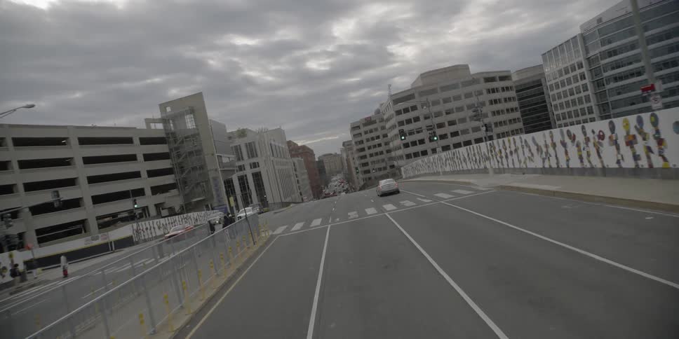 A street with only a few cars and people is being travelled