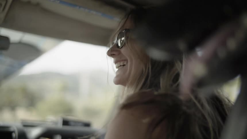 A woman laughs while riding in a vehicle