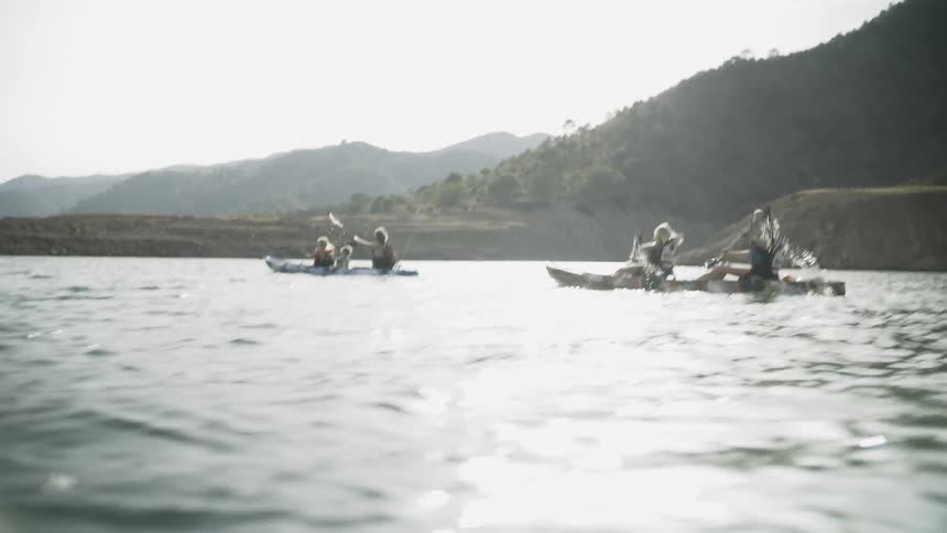 People kayak on a mountain lake