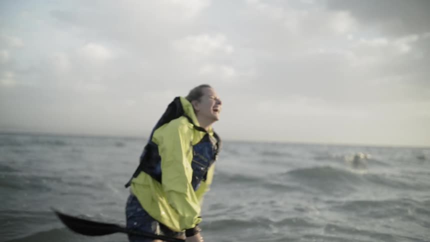 A woman is in the ocean laughing