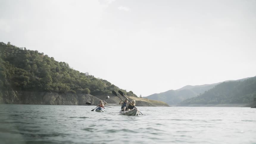 People paddle kayaks on the water